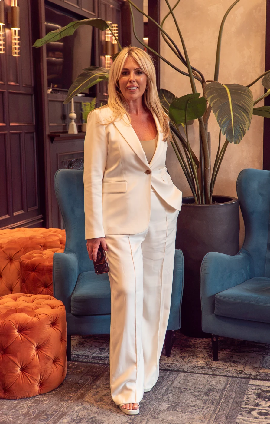 Elizabeth, founder of Aura Property Partners, standing in a white suit